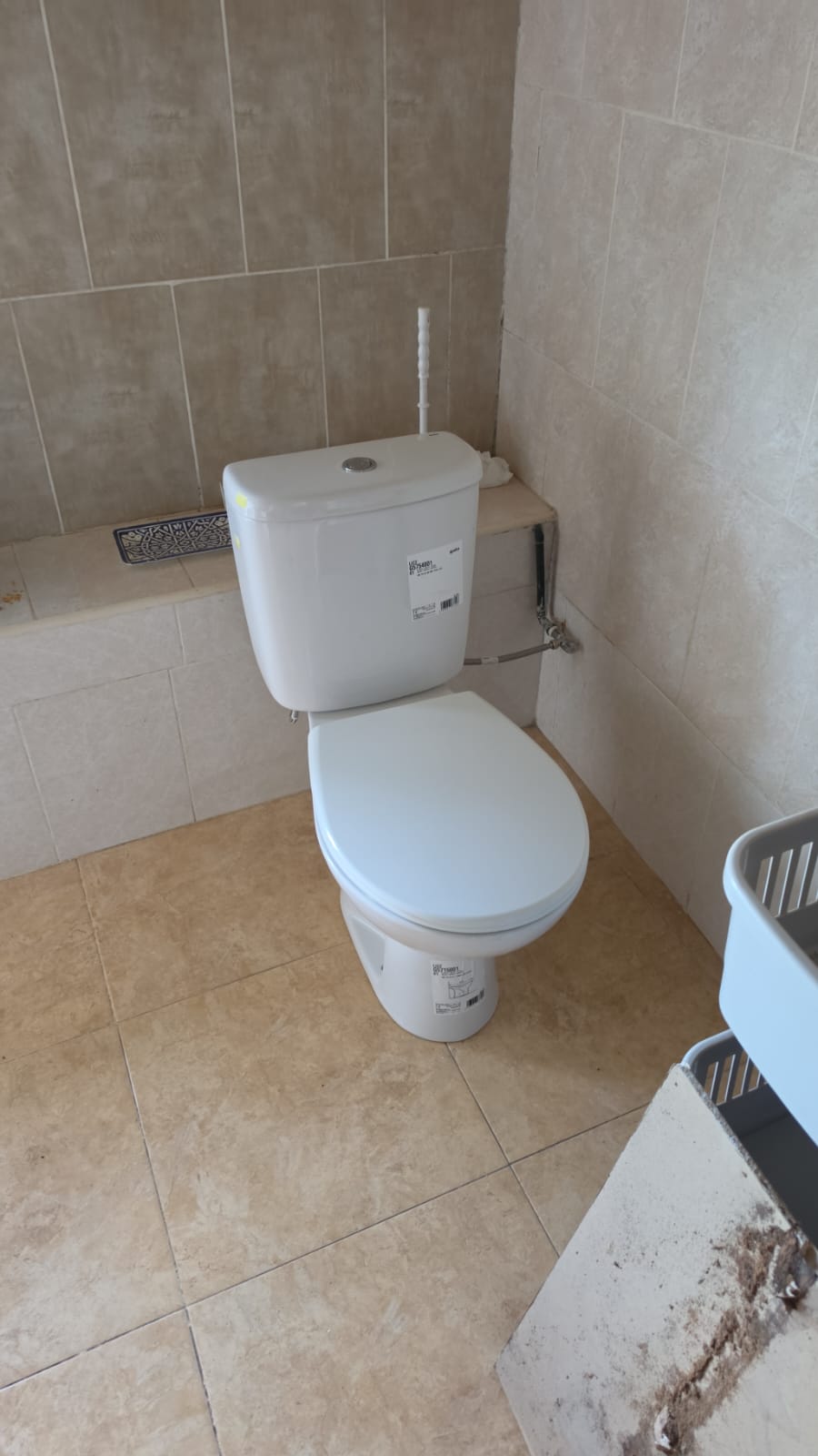 Nuevo inodoro instalado en el mismo baño, con cisterna, pulsador y tapa nuevos